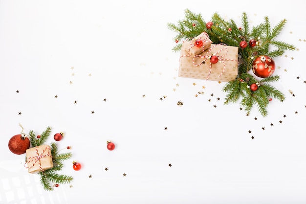 Fondo de Navidad o año nuevo, composición de adornos navideños rojos, regalos y ramas de abeto sobre fondo blanco, plano, espacio en blanco para un texto de saludo