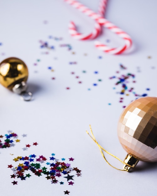 Fondo de Navidad o año nuevo con confeti de bolas de Navidad doradas y fondo azul de bastón de caramelo