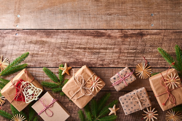 Fondo de Navidad o año nuevo con ramas de abeto, bolas de Navidad, caja de regalo, copos de nieve de madera y estrellas sobre fondo de madera oscura. Lugar para tu texto