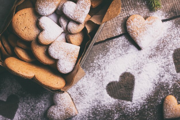 Foto fondo de navidad. pasteles caseros para el día de san valentín: galletas de jengibre en forma de corazones en la caja vieja