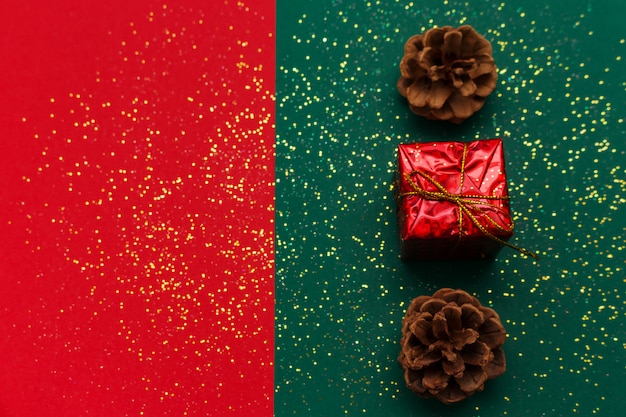 Foto fondo de navidad con piñas, brillo dorado brillante y caja de regalo en tradicional