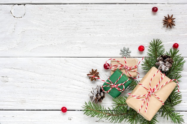 Fondo de Navidad con ramas de abeto, adornos, cajas de regalo y piñas en la mesa de madera blanca. Fondo de Navidad. Endecha plana. vista superior con espacio de copia