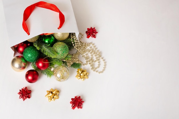 Fondo de Navidad con ramas de abeto adornos rojos y dorados sobre un fondo blanco.