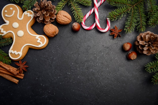 Fondo de Navidad con ramas de abeto, conos, especias y pan de jengibre.