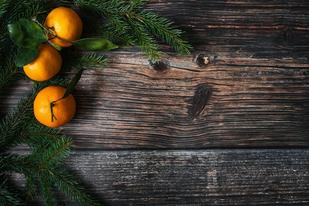 Fondo de Navidad con ramas de abeto y mandarinas en mesa de madera