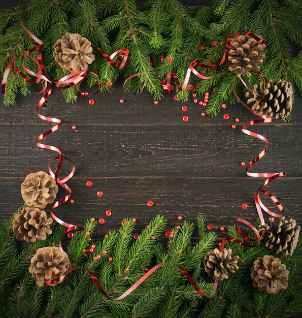 Fondo de Navidad con ramas de abeto y piñas en mesa de madera