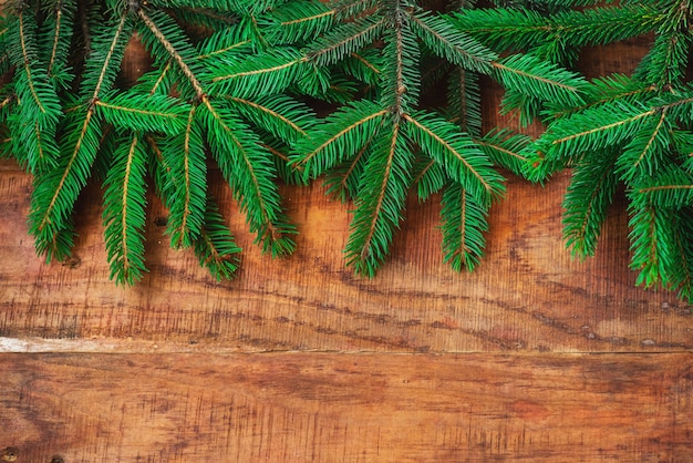 Fondo de Navidad. Ramas de abeto sobre un fondo de madera. Copie el espacio, marco, lugar para el texto