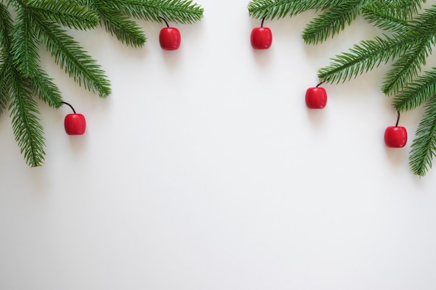 Fondo de navidad con ramas de abeto verde y pequeños juguetes rojos