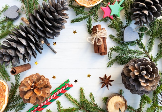 Foto fondo de navidad ramas de árboles de navidad conos de pino canela anís estrellado chips de naranja sobre un fondo blanco con espacio para texto diseño de un cartel de postal