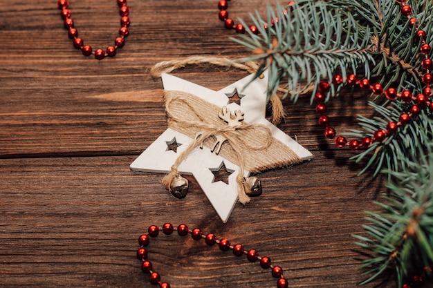 Fondo de Navidad con ramita de abeto y juguetes rojos sobre tablas de madera.