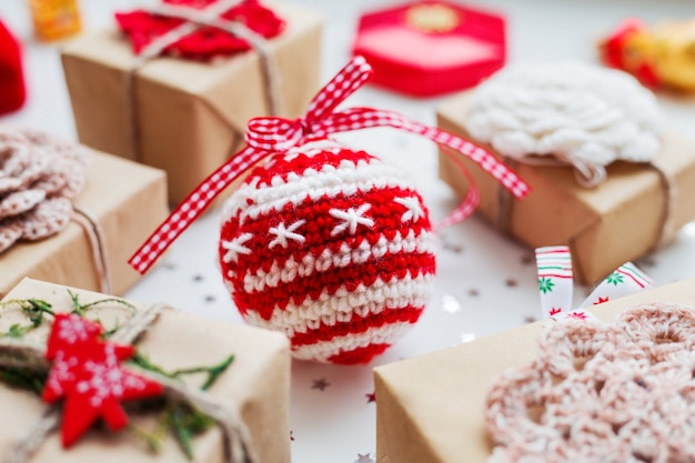 Foto fondo de navidad con regalos, decoraciones y ganchillo hecho a mano bola decorativa.