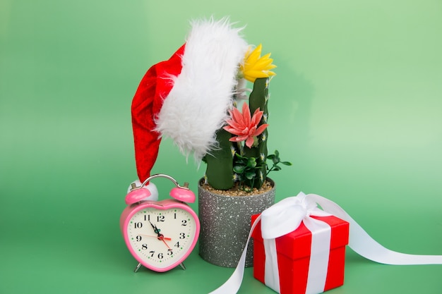 Fondo de Navidad. sombrero de santa claus en una flor y una caja de regalo con un reloj despertador