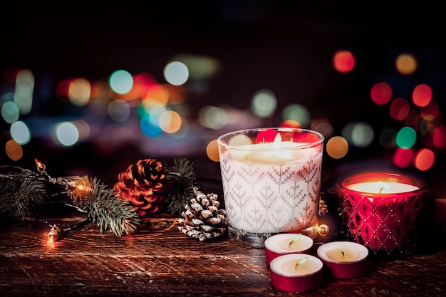 Fondo de Navidad - Vela de Navidad y decoración rústica en la mesa de madera con luces de Navidad de fondo en la noche de fiesta. estilo del color de la vendimia.