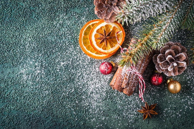 Fondo de Navidad verde. Composición con naranjas secas y palitos de canela.