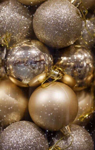 Foto fondo navideño con adornos de bolas doradas brillantes en envases transparentes para árbol de navidad tarjeta de año nuevo de navidad conjunto de decoración de bolas de plata y oro de navidad con chispas