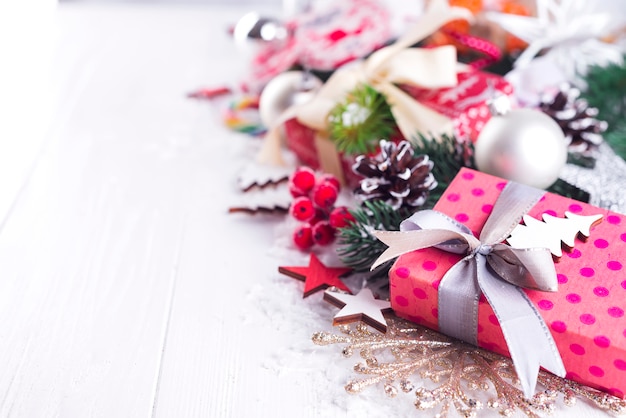 Fondo navideño con cajas de regalo, árbol de navidad, mitones y decoraciones.