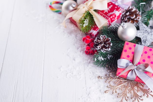 Fondo navideño con cajas de regalo, árbol de navidad, mitones y decoraciones.