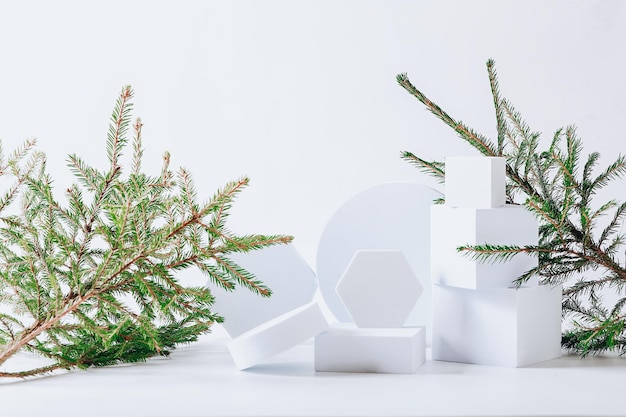 Fondo navideño escandinavo ecológico minimalista en colores blancos Ramas de abeto y podio blanco vacío