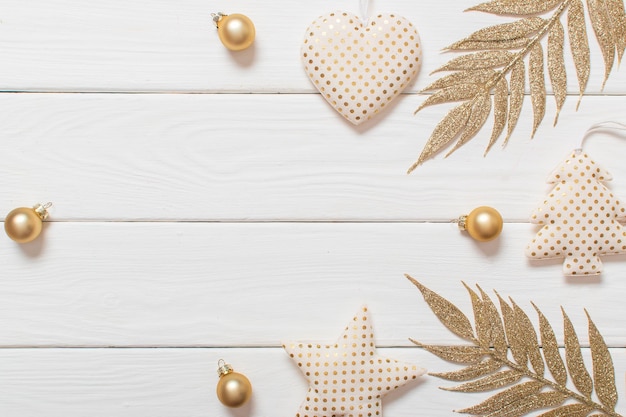 Fondo navideño Juguetes navideños con puntos dorados sobre un fondo blanco de madera con un lugar para el texto