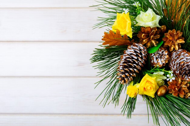 Fondo navideño con piñas doradas y rosas amarillas de tela