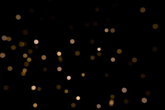 Fondo negro con efectos de luz dorada bokeh para la época navideña Foto