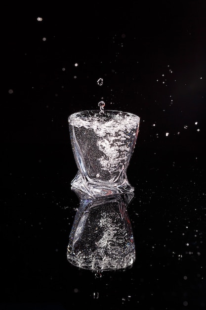 Foto el fondo negro es un escaneo en el que se vierte agua. salpicaduras de agua sobre el vidrio