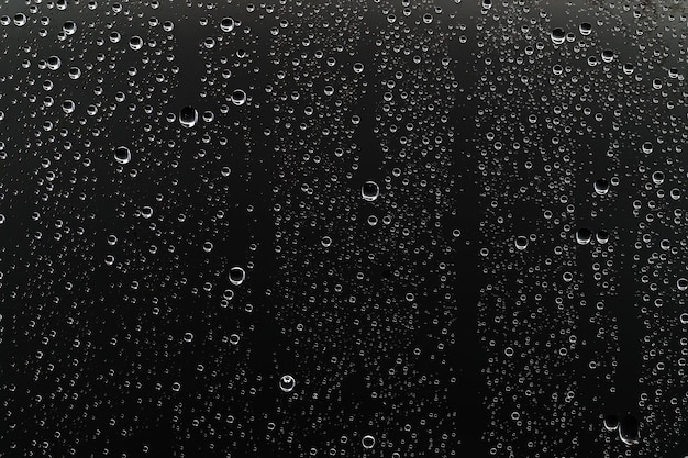 Fondo negro húmedo / gotas de lluvia para superponer en la ventana, concepto de clima otoñal, fondo de gotas de lluvia de agua sobre vidrio transparente