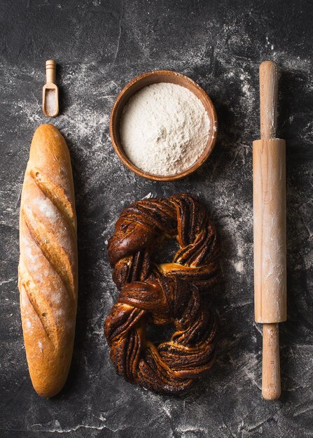 Fondo negro de panadería con pan y panecillos planos