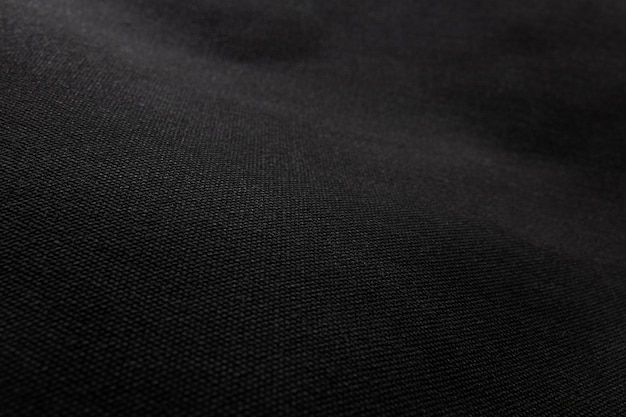 Fondo negro de la textura de la tela. Detalle de material textil lienzo.
