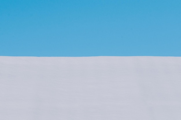 Fondo de nieve fresca y el cielo azul Fondo blanco de invierno Minimalismo concepto de diseño simple