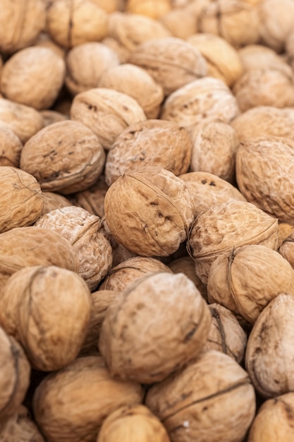 Fondo de nogal natural con marco de bordes borrosos. Nueces con cáscara de alimentos naturales