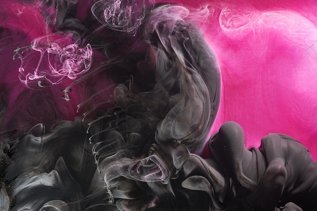 Fondo oceánico abstracto rosa oscuro y negro Salpicaduras de gotas y olas de pintura bajo nubes de humo en movimiento