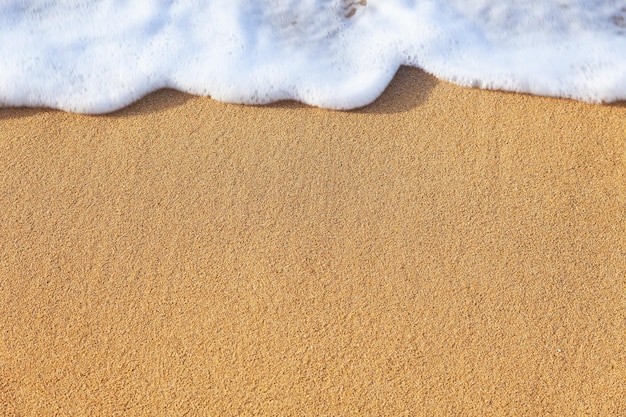 Fondo del océano Onda suave del agua en la playa de arena