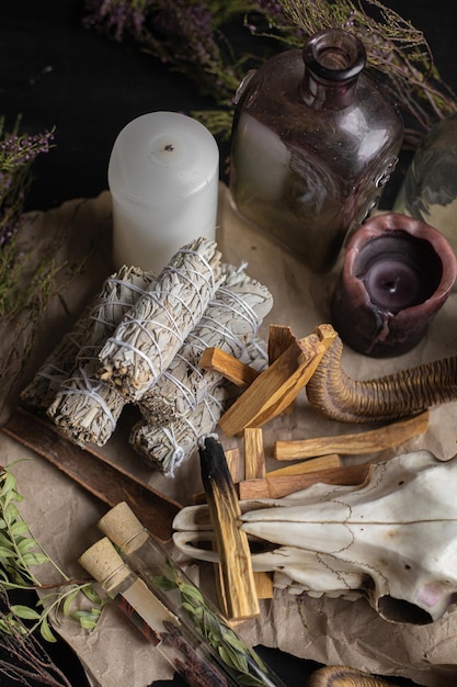 Foto fondo oculto mágico con velas, varitas de incienso, hierbas, cráneo.