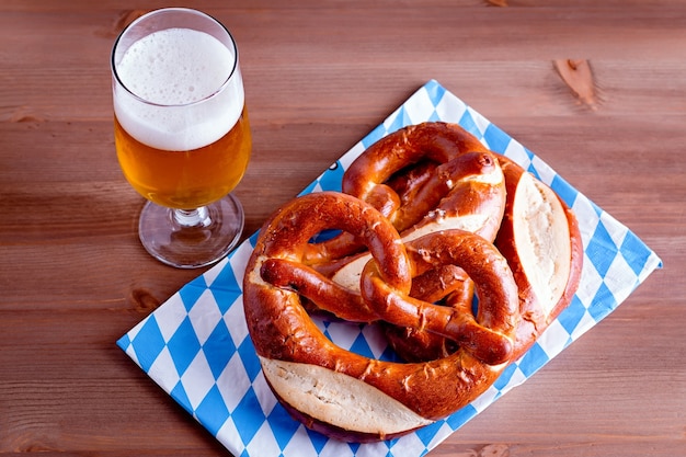 Fondo de Oktoberfest con cerveza y pretzels y primer plano de la decoración bávara tradicional en la parte superior de la mesa de madera