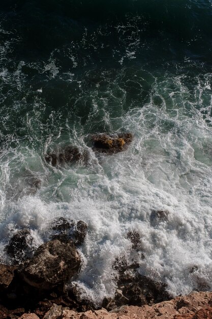 Fondo de ola oceánica rompiendo agua de mar costa rocosa