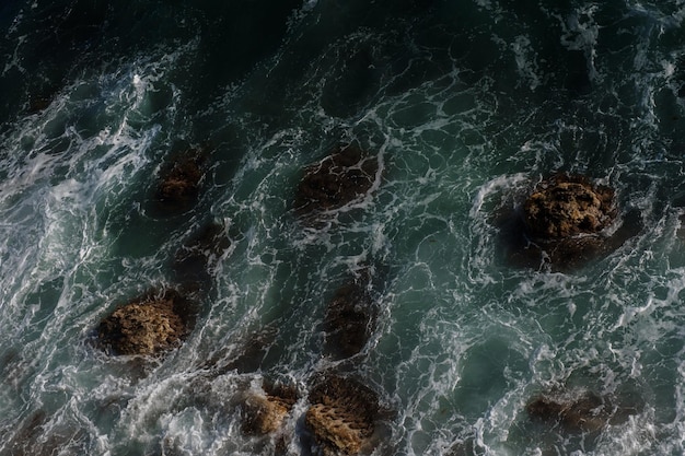 Fondo de ola oceánica rompiendo agua de mar costa rocosa