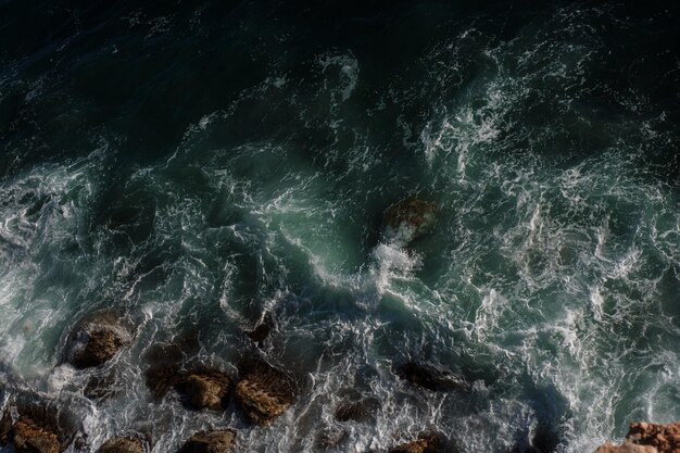 Fondo de ola oceánica rompiendo agua de mar costa rocosa