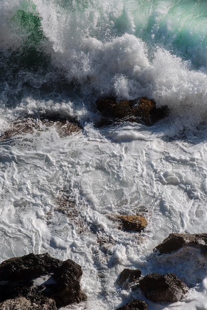 Fondo de ola oceánica rompiendo agua de mar costa rocosa