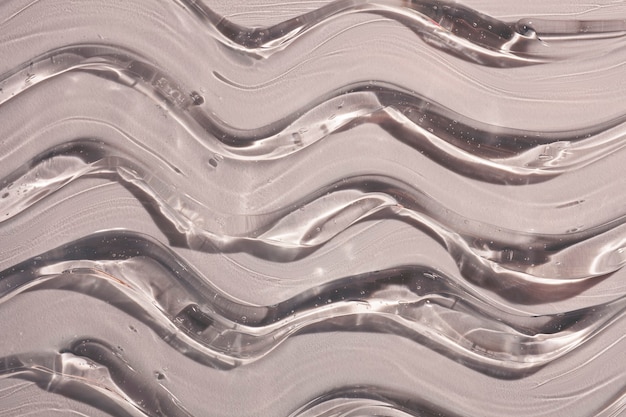 Fondo de ondas de textura de muestra cosmética transparente gris crema gel