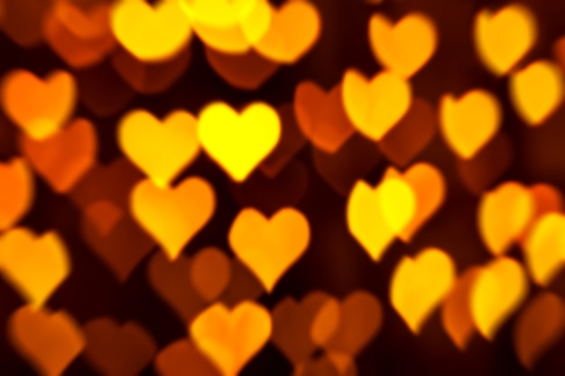 Fondo de oro abstracto con el bokeh en forma de corazón