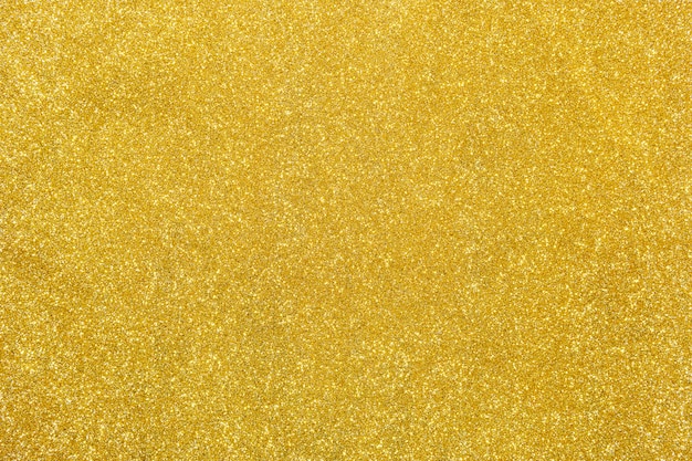 Foto fondo de oro del extracto de la textura del brillo del color para el diseño.