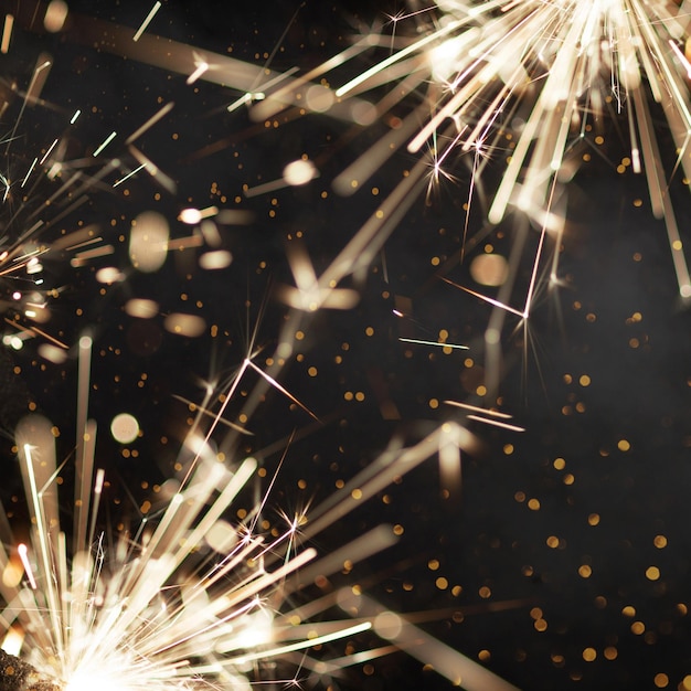 Fondo oscuro con bengalas encendidas y texto Feliz Navidad y Próspero Año Nuevo
