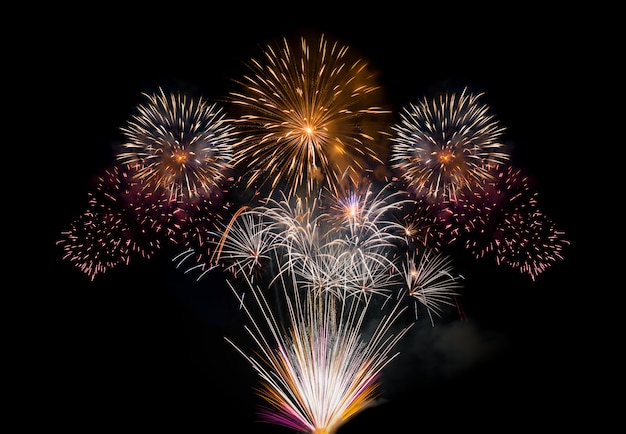 Foto fondo oscuro de fuegos artificiales grandes de oro y amarillo en la noche para año nuevo o celebración especial de vacaciones