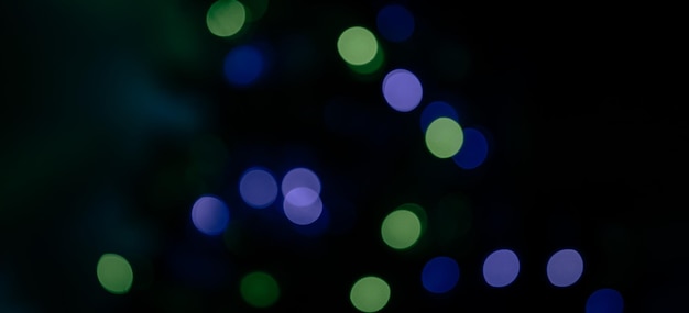 fondo oscuro iluminado con luces verdes azules y violetas borrosas para crear un efecto bokeh