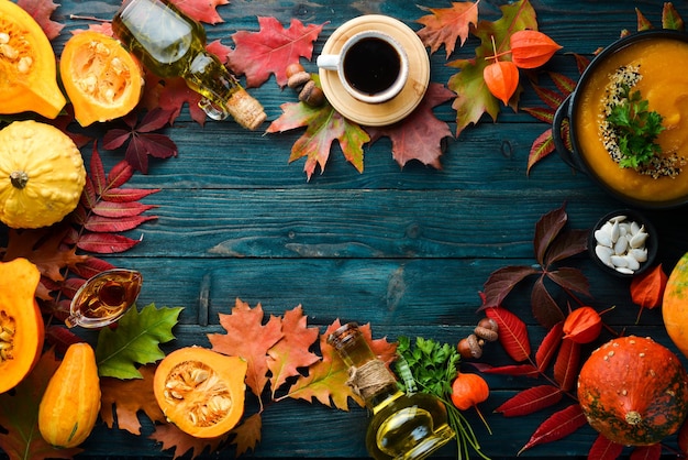 Fondo de otoño con café, calabaza, hojas de otoño. endecha plana Sobre un fondo de madera azul. Vista superior. Espacio libre para su texto.