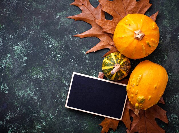 Fondo de otoño con calabazas y hojas secas.