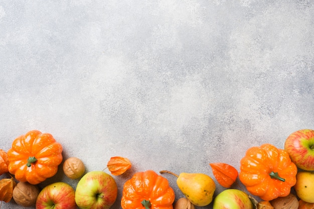 Foto fondo de otoño con hojas amarillas, calabazas, manzanas, peras y nueces