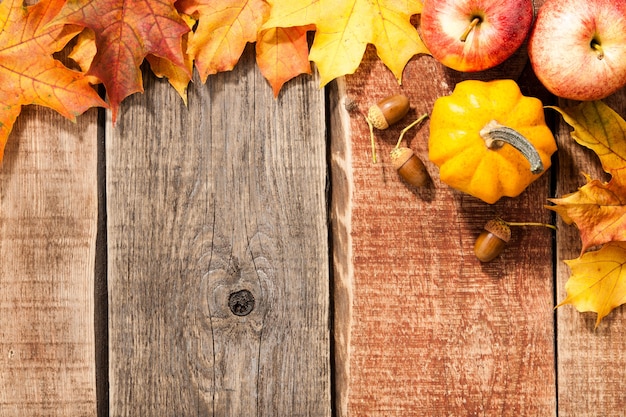 Fondo de otoño con hojas de arce, calabaza, bellotas y manzanas