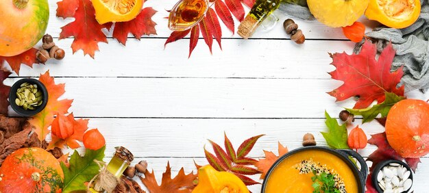 Fondo de otoño con hojas de otoño de calabaza de café sobre un fondo de madera blanca Vista superior Espacio libre para su texto